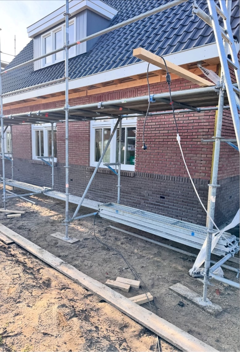 Nieuwbouwwoning op Texel in de steiger, de rode gevel is tot onder de dakrand gemetseld